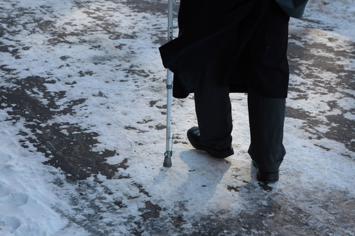 vanhus kävelee lumisella tiellä