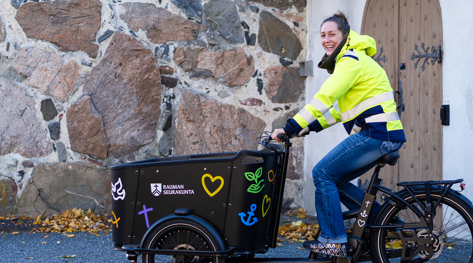 Kuva: Nainen istuu sähköpyörän päällä ja hymyilee.