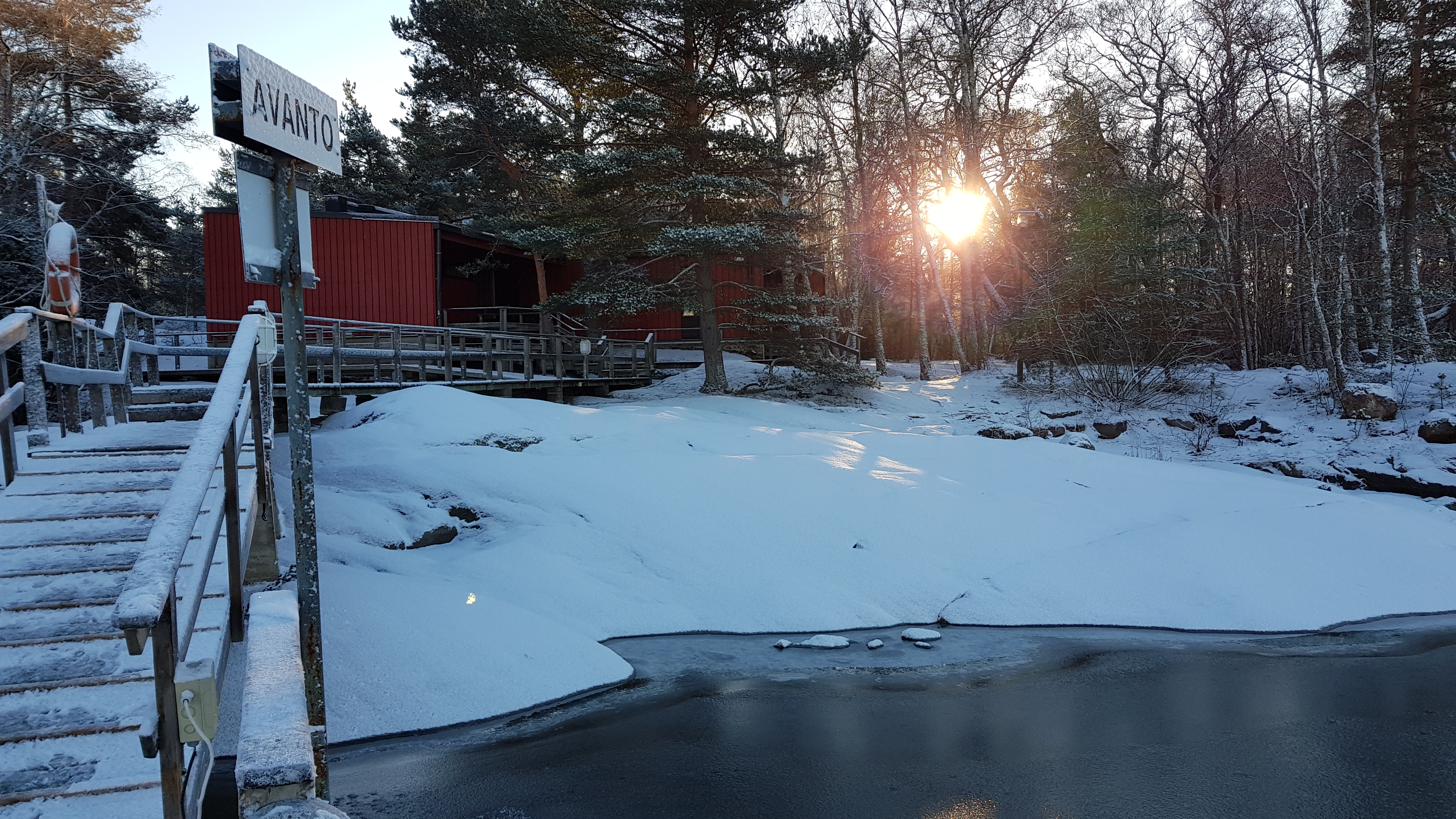 Luminen ranta, jossa näkyy Meriristin leirikeskuksen saunarakennusta ja laituria.