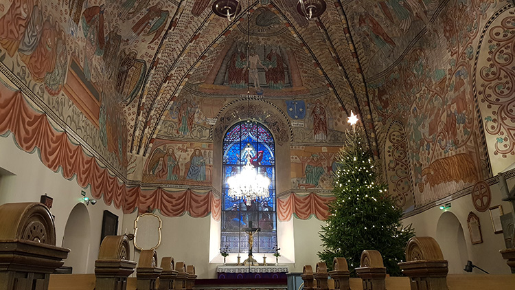 Pyhän Ristin kirkon sisätilaa, jossa näkyy joulukuusi jouluvaloineen
