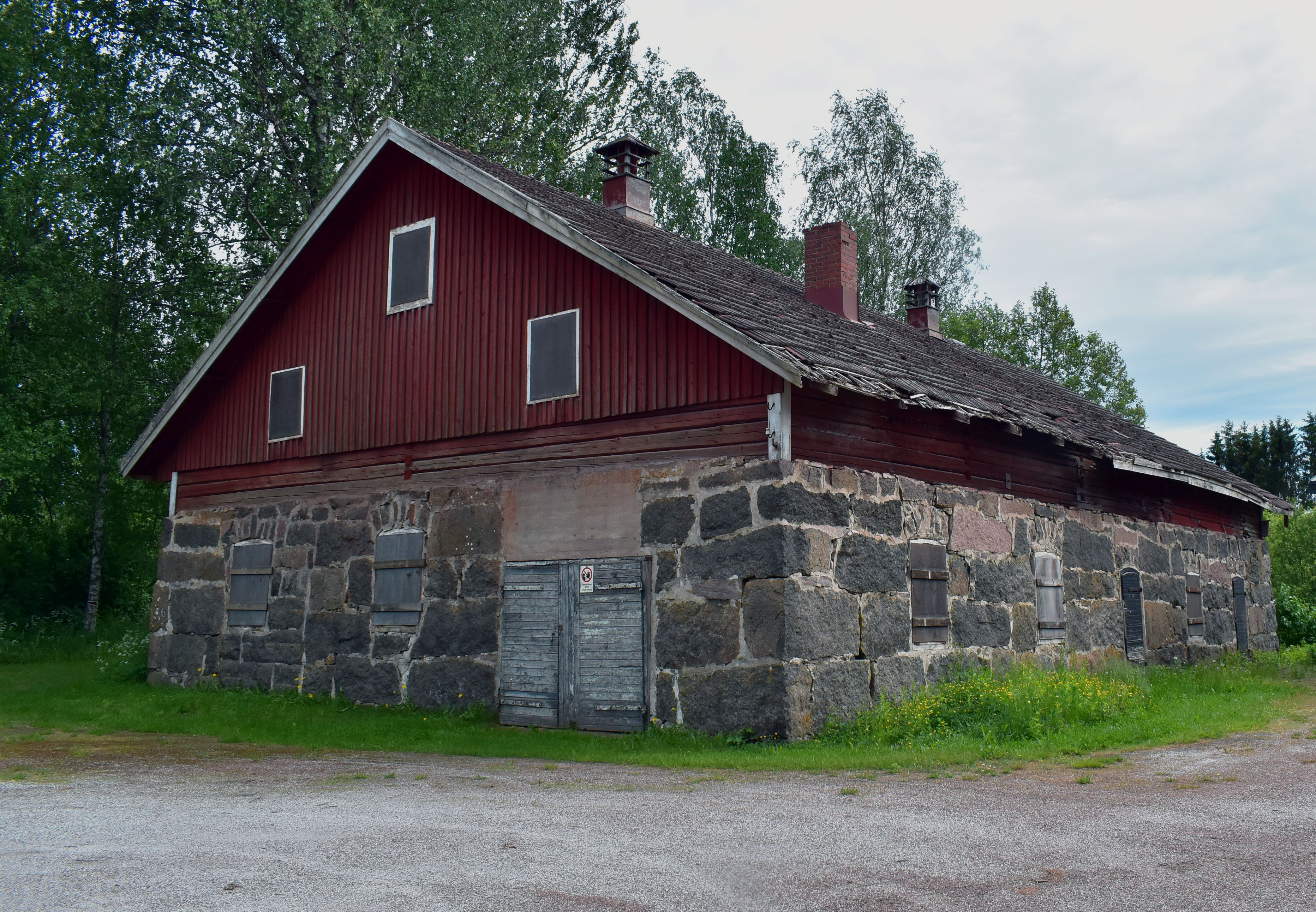 Lapin pappilan vanha tiilirakenteinen navetta. Navetta on huonokuntoisen näköinen ja katto repsottaa.