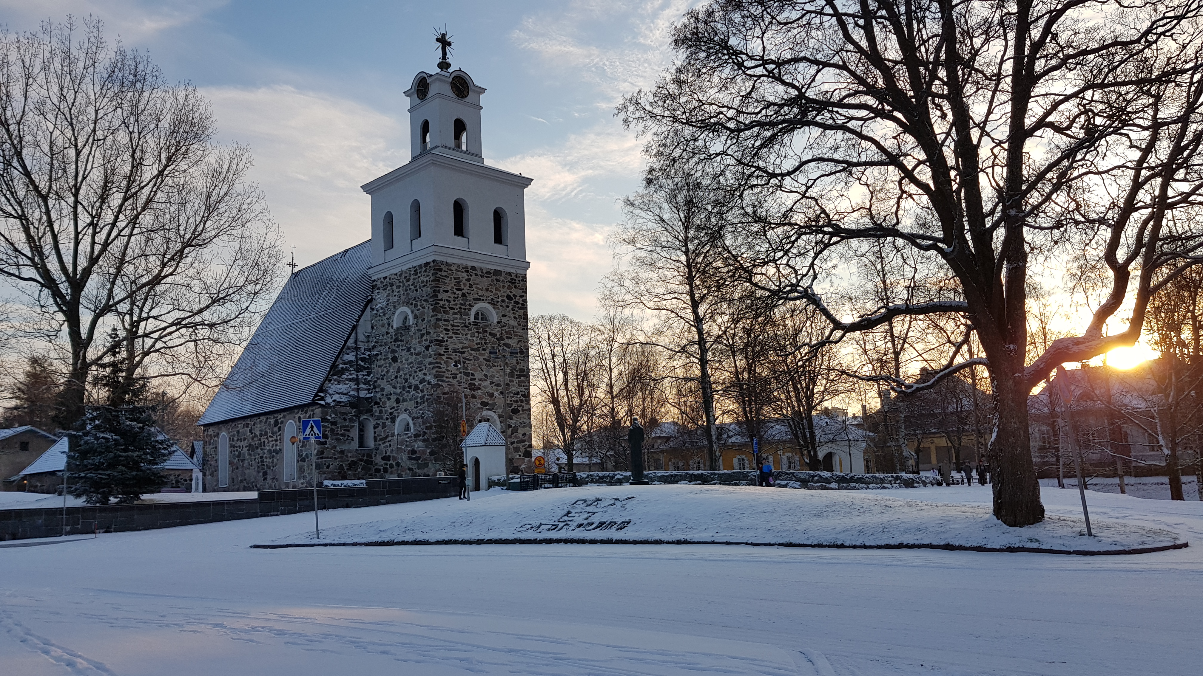 Pyhän Ristin kirkko lumettomana talvipäivänä, lehdettömiä puita.