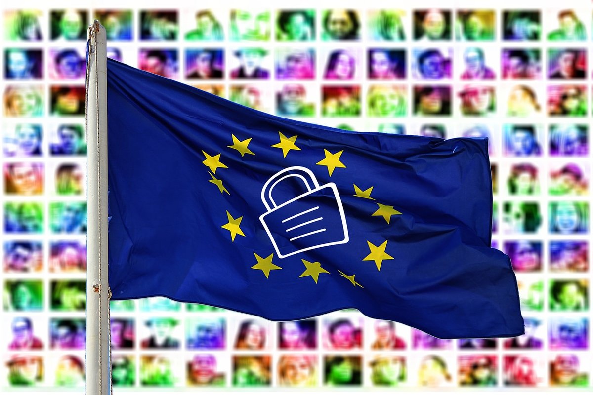 Kuvassa on EU-lippu, joissa sinisellä pohjalla tähtien ympäröimänä on lukon kuvake. Taustalla ihmisten kasvoja
